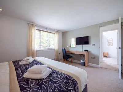 a bedroom with a bed and a desk with a computer at The Valley in Perranwell
