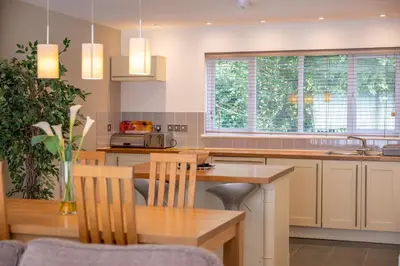 a kitchen with a wooden table and a counter top at The Valley in Perranwell