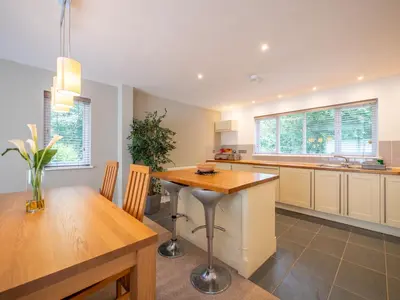 a kitchen with a wooden table and a dining room at The Valley in Perranwell