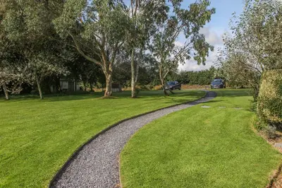 a gravel path in a park with trees and grass at Treweens in Wadebridge