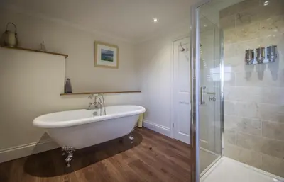 a bathroom with a bath tub and a shower at Treweens in Wadebridge