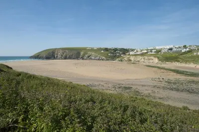 a sandy beach with houses on top of a bluff at White Lodge Apartments in Mawgan Porth