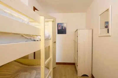 a room with two bunk beds and a closet at White Lodge Apartments in Mawgan Porth