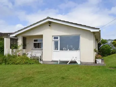 a small white house with a large window at Merriview in Germoe