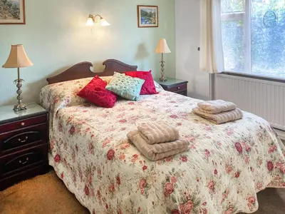 a bedroom with a large bed with blankets and pillows at Merriview in Germoe