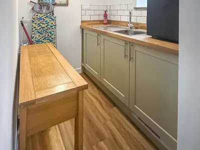 a kitchen with a sink and a wooden counter at Ostlers in Boscastle