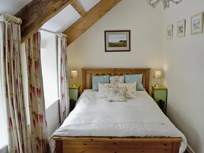 a bedroom with a bed with white sheets and pillows at Ostlers in Boscastle