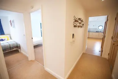 a hallway with a door leading to a bedroom at Horizons Apartments Newquay in Newquay