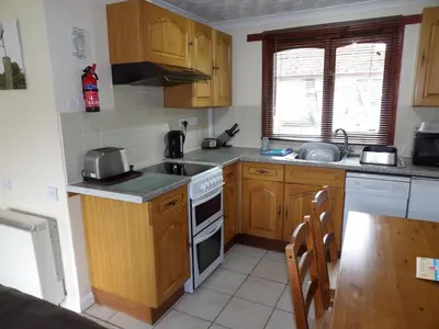 a kitchen with wooden cabinets and a stove top oven at Hengar Select in Saint Tudy