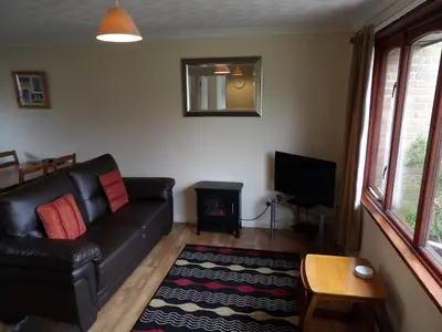 a living room with a black leather couch and a fireplace at Hengar Select in Saint Tudy