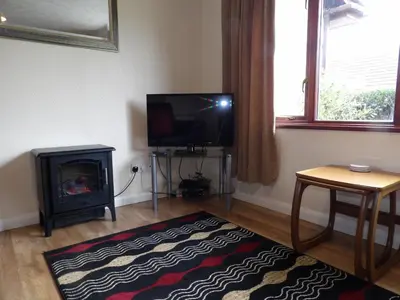 a living room with a fireplace and a television at Hengar Select in Saint Tudy