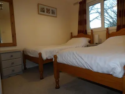 a bedroom with two beds and a mirror and a window at Hengar Select in Saint Tudy