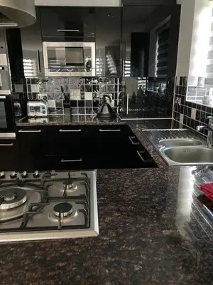 a kitchen with a stove top and a sink at Shorthorn Apartment, 53a Sea Road in Carlyon Bay