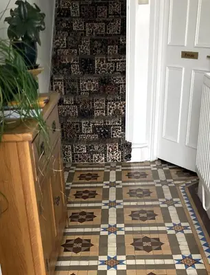 a hallway with a tiled floor with a tile wall at Donnington Guesthouse in Truro