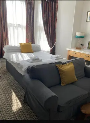 a large bed in a room with a couch at Donnington Guesthouse in Truro