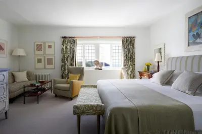 a bedroom with a bed and a chair and a window at Hotel Tresanton in Saint Mawes