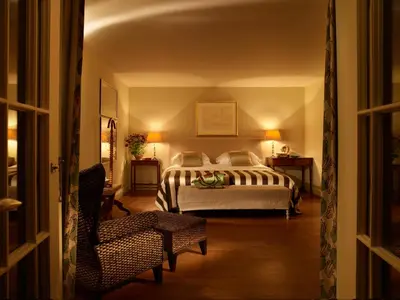 a bedroom with a bed and a chair at Hotel Tresanton in Saint Mawes