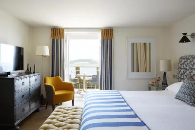 a bedroom with a bed and a television and a chair at Hotel Tresanton in Saint Mawes
