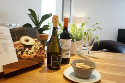 a table with two bottles of wine and a bowl of nuts at Ocean Views 4 in Newquay