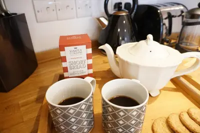 two cups of coffee and a tea pot on a table at Ocean Views 4 in Newquay