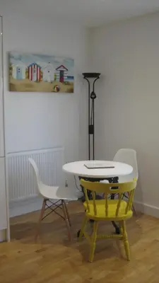 a table and chairs in a room with a painting at SeaQuest 1 in Newquay