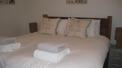 a white bed with towels on top of it at SeaQuest 1 in Newquay
