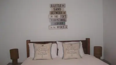 a bed with two pillows and a sign on the wall at SeaQuest 1 in Newquay