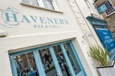 a sign for a bar and grill on the side of a building at Havener's in Fowey