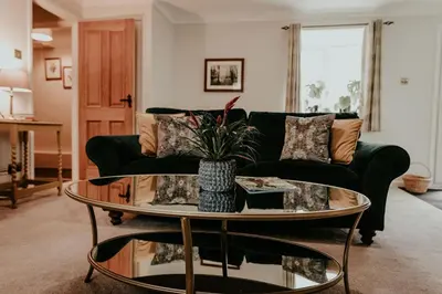 a living room with a green couch and a table at Higher Trewithen in Stithians