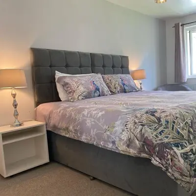 a bedroom with a large bed with a large headboard at Higher Trewithen in Stithians