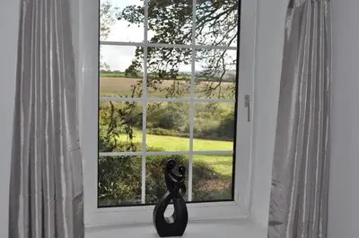 a window with a pair of scissors on a window sill at Higher Trewithen in Stithians