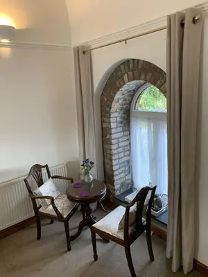 a room with a table and two chairs and a window at The Chapel Guest House in St Austell