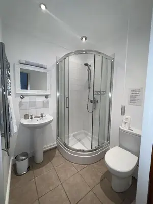 a bathroom with a shower and a toilet and a sink at The Chapel Guest House in St Austell