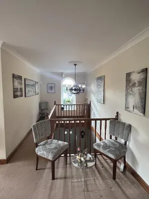 a living room with two chairs and a glass table at The Chapel Guest House in St Austell