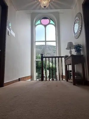 a room with a large window and a table with a lamp at The Chapel Guest House in St Austell