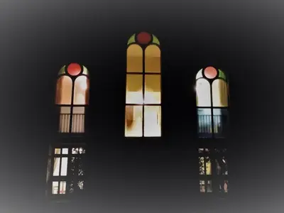 three stained glass windows with their reflections in the water at The Chapel Guest House in St Austell