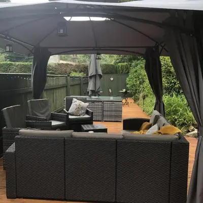 a large black umbrella on a patio with furniture at The Chapel Guest House in St Austell