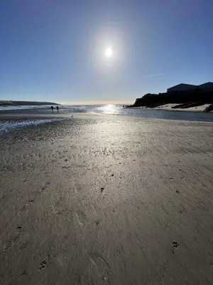 a beach with the sun shining on the sand at The Chapel Guest House in St Austell