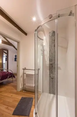 a glass shower stall in a room with a staircase at Red River Stables - Peaceful, beautiful grounds, swimming pool, central location for West Cornwall in Camborne