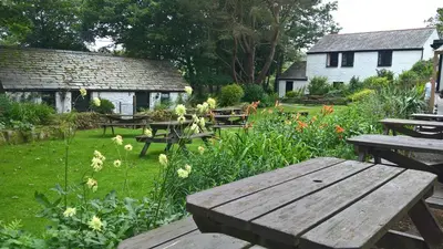 a wooden bench sitting in the middle of a garden at The Crown Inn in Lanlivery