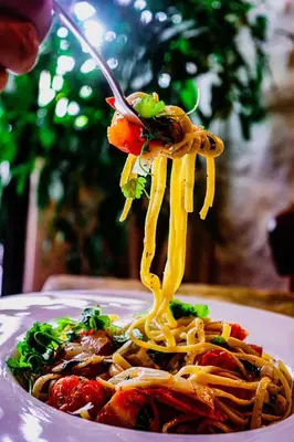 a plate of spaghetti with a fork in it at The Crown Inn in Lanlivery