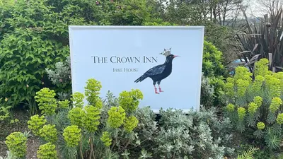a sign for a garden with a bird on it at The Crown Inn in Lanlivery
