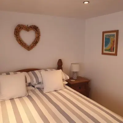 a bedroom with a bed with a heart on the wall at Chynoweth Mews in Newquay