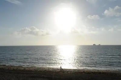 a person walking on the beach near the ocean at Anacapri in Falmouth