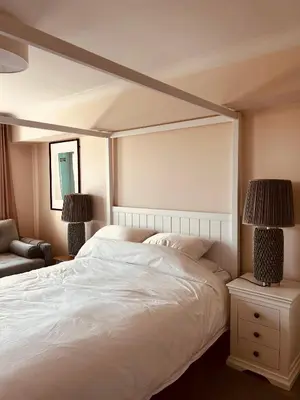 a bedroom with a large white bed and two lamps at Pentire Headland Retreat in Newquay