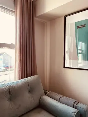 a couch sitting in a room with a window at Pentire Headland Retreat in Newquay