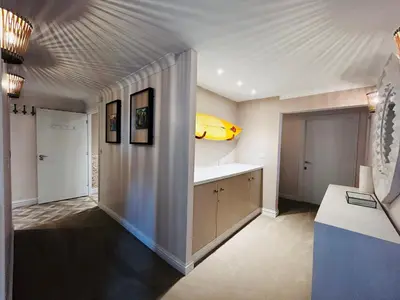 a living room with a yellow surfboard on the wall at Pentire Headland Retreat in Newquay