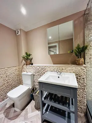 a bathroom with a toilet and a sink and a mirror at Pentire Headland Retreat in Newquay