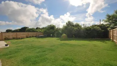 a large yard with a picnic table and a fence at Luxurious House in Cornwall in Truro