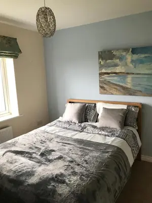 a bedroom with a bed with a painting on the wall at Luxurious House in Cornwall in Truro